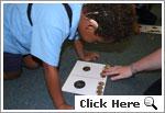 Picture of a student placing coins on a scaffold Picture of a student placing coins on a scaffold